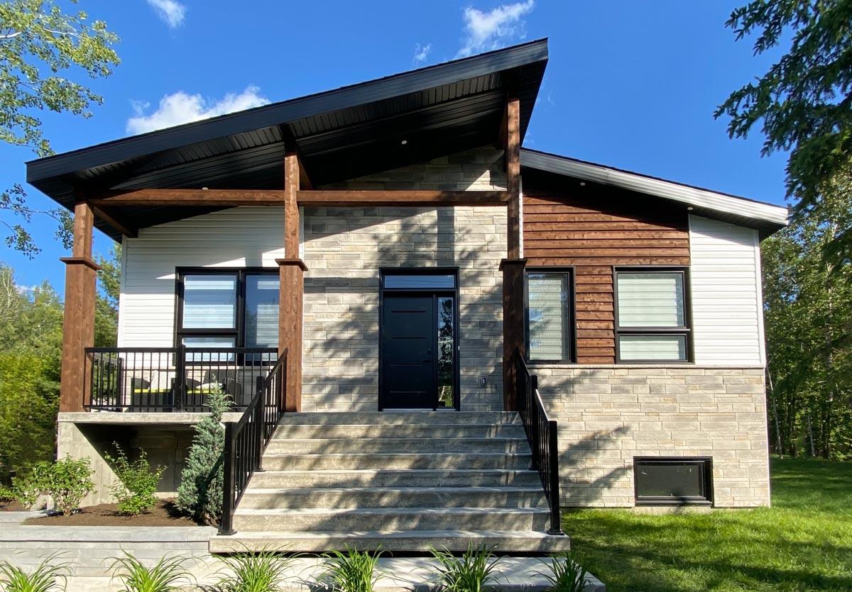 House plan exterior with modern asymmetrical roof, stone and wood siding, and covered porch with wooden beams.