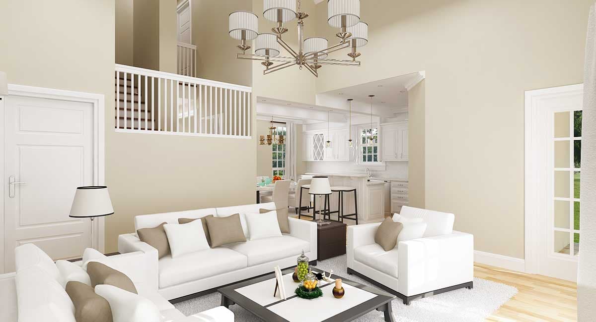 Great room with vaulted ceiling, white sofas, fireplace, and open kitchen with island.