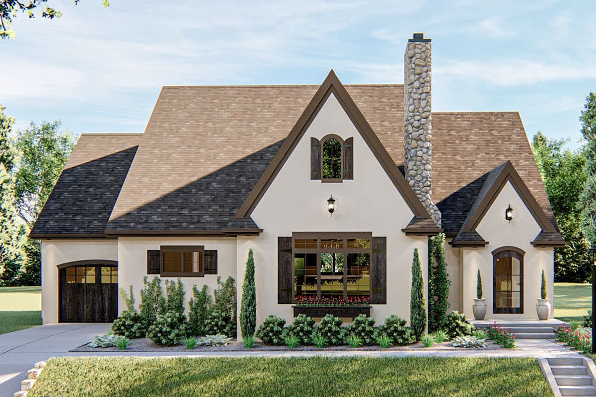 House plan exterior. One-story French Country style home with stone chimney, multiple gables, and dark-trimmed windows with shutters.