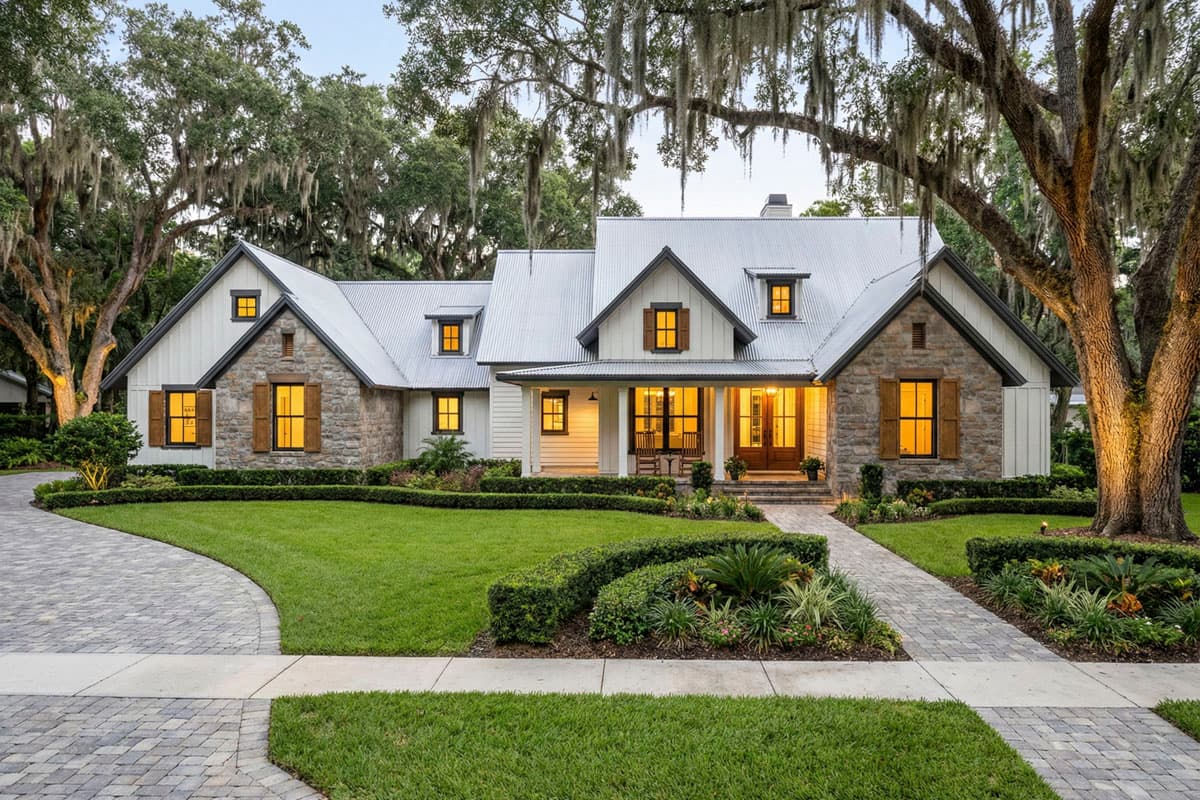House plan exterior with stone and siding, a metal roof, dormers, and a front porch. Farmhouse style home with gables.