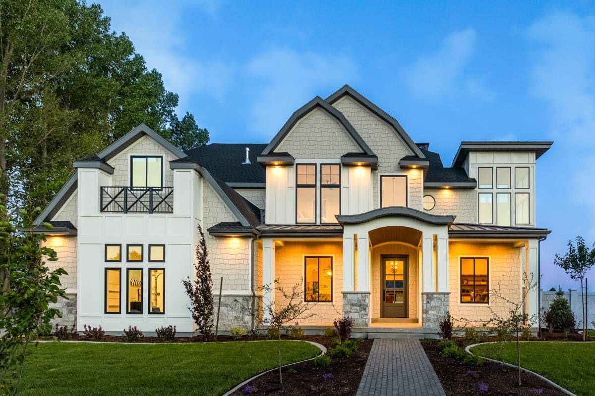 House plan exterior with two stories, Craftsman style. Features include gabled rooflines, a covered entry porch, and upper-level balcony.