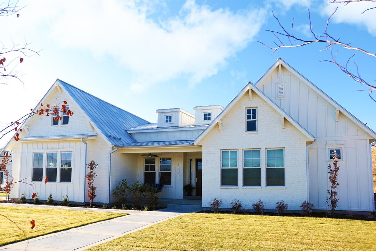House plan exterior. Two-story Modern Farmhouse with gables, metal roof, and covered porch. Features include board and batten siding.