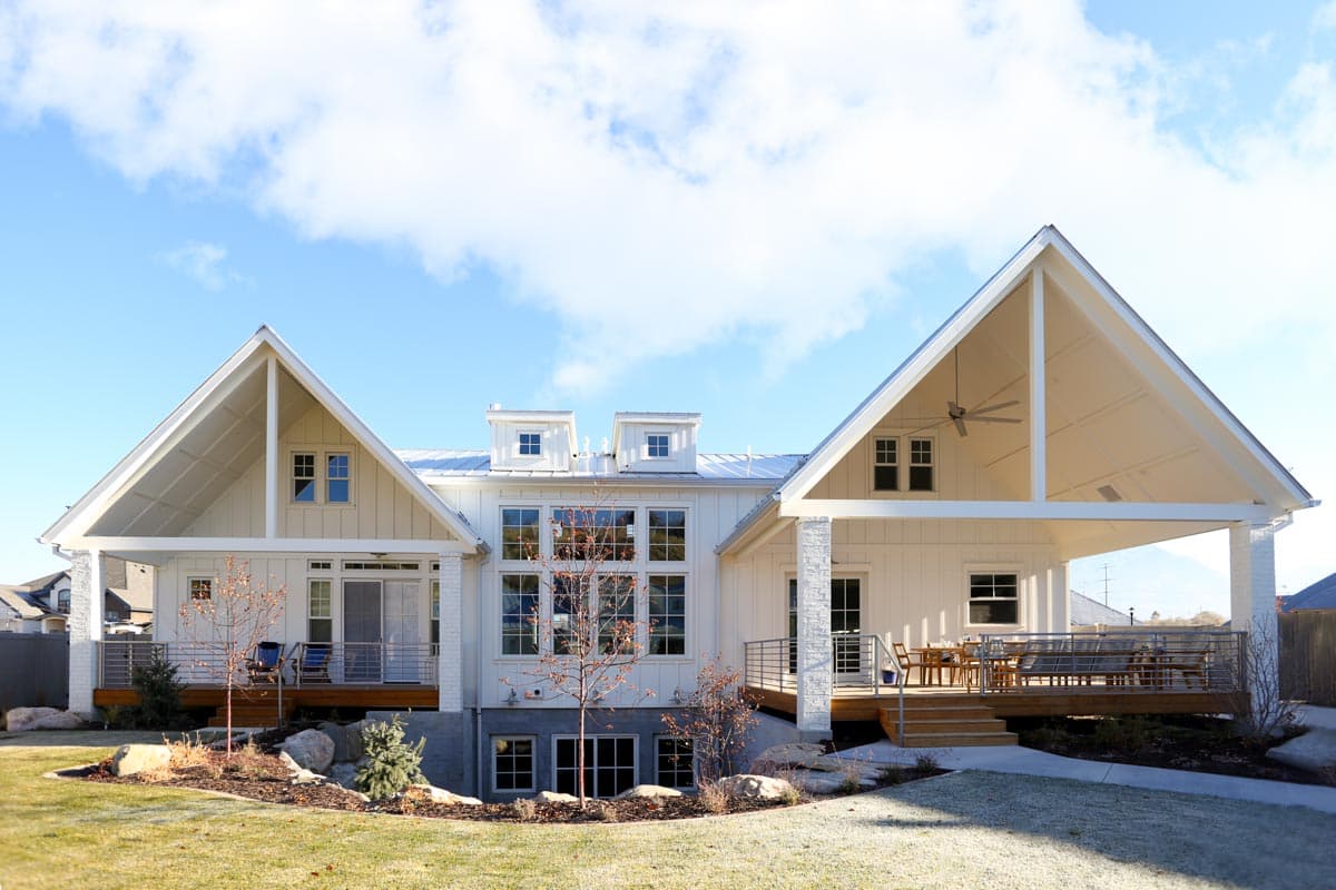 Modern Farmhouse house plan exterior with gables, dormers, and a covered porch with outdoor seating.
