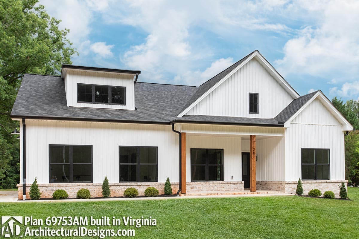 Modern Farmhouse style house plan exterior with white board and batten siding, brick base, dormer, and timber porch columns.