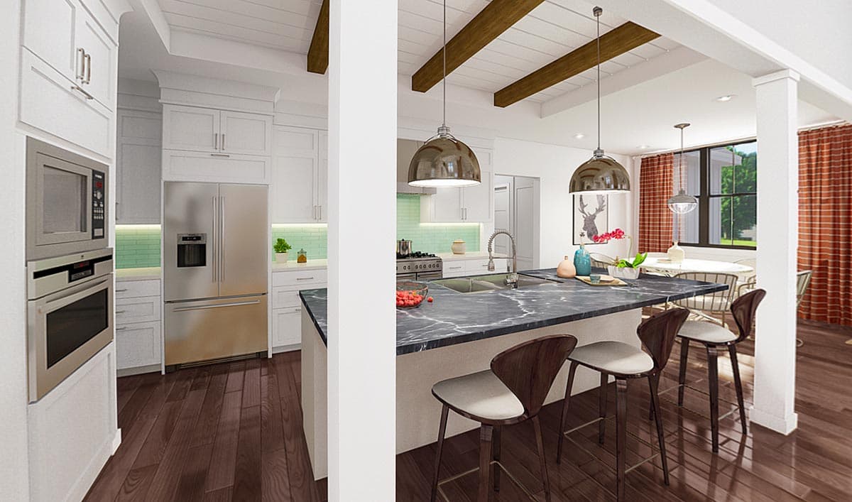 Open concept kitchen with island, stainless steel appliances, white cabinetry, wood beams, and dining area.