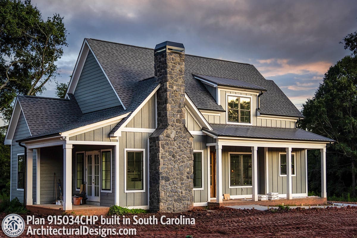House plan exterior with a prominent stone chimney, gabled dormers, and covered porches.