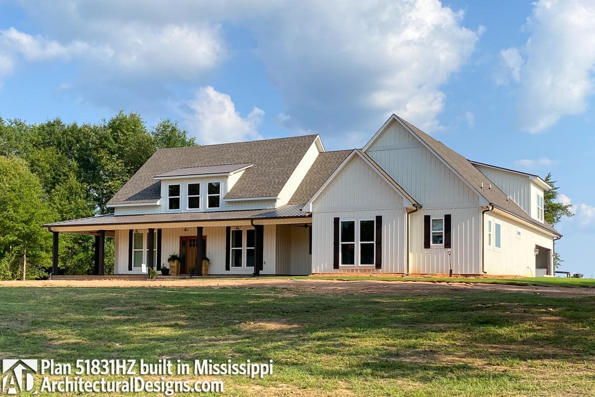 House plan exterior: Modern Farmhouse style, two stories, wraparound porch, gables, and dormer windows.