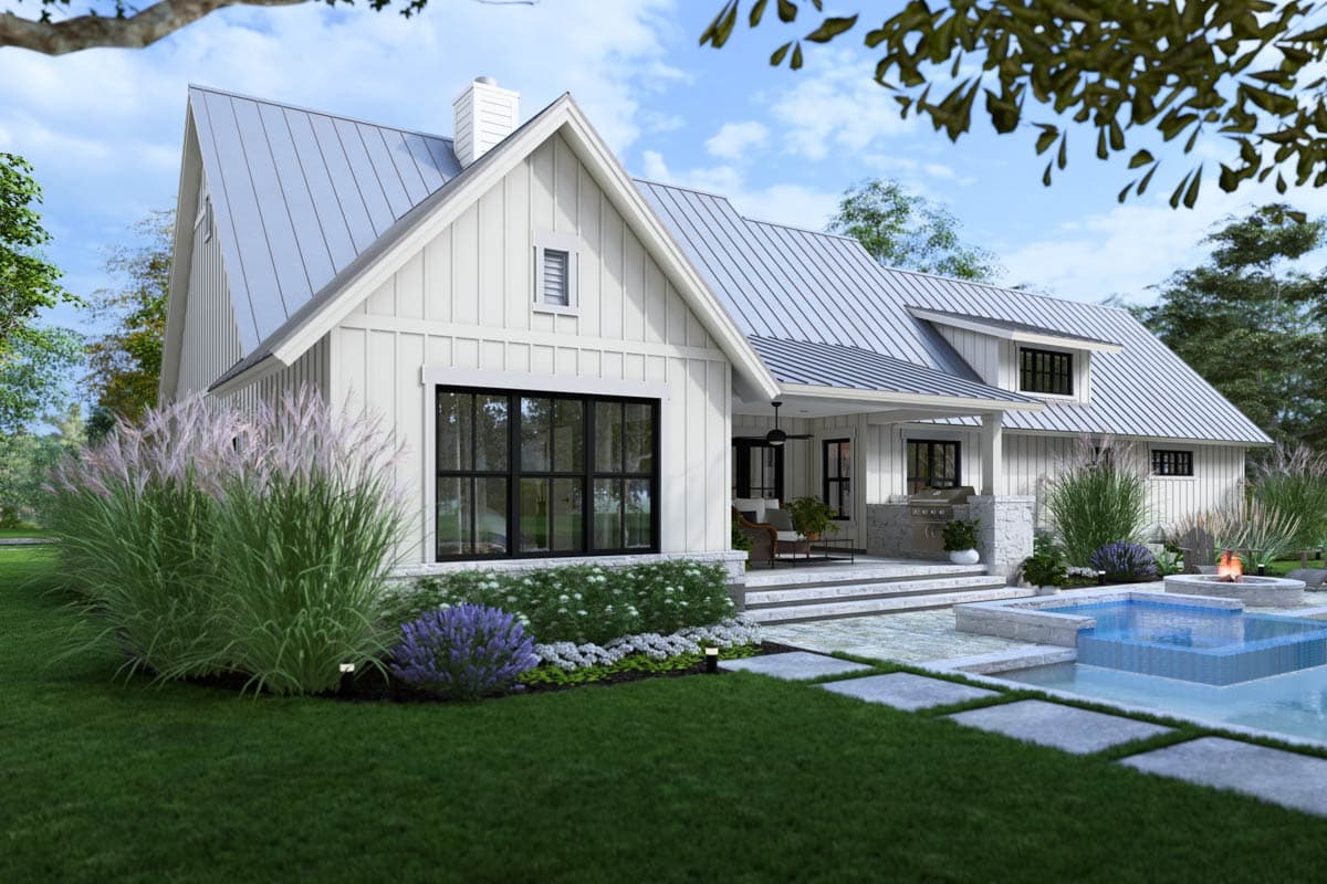 Modern farmhouse with white siding, black-framed windows, and a metal roof. Features include a patio, pool, and well-manicured landscaping.
