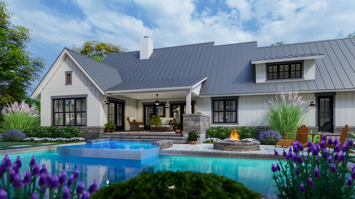 A modern farmhouse with a pool, fire pit, and outdoor seating. The house features a gray roof and white siding, with lush landscaping.