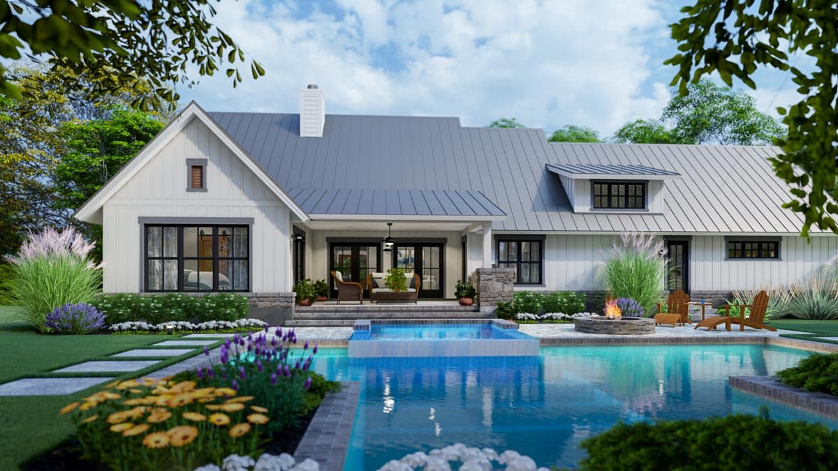 A modern white house with a pool, patio, and lush landscaping. The backyard features a fire pit, Adirondack chairs, and a serene water view.