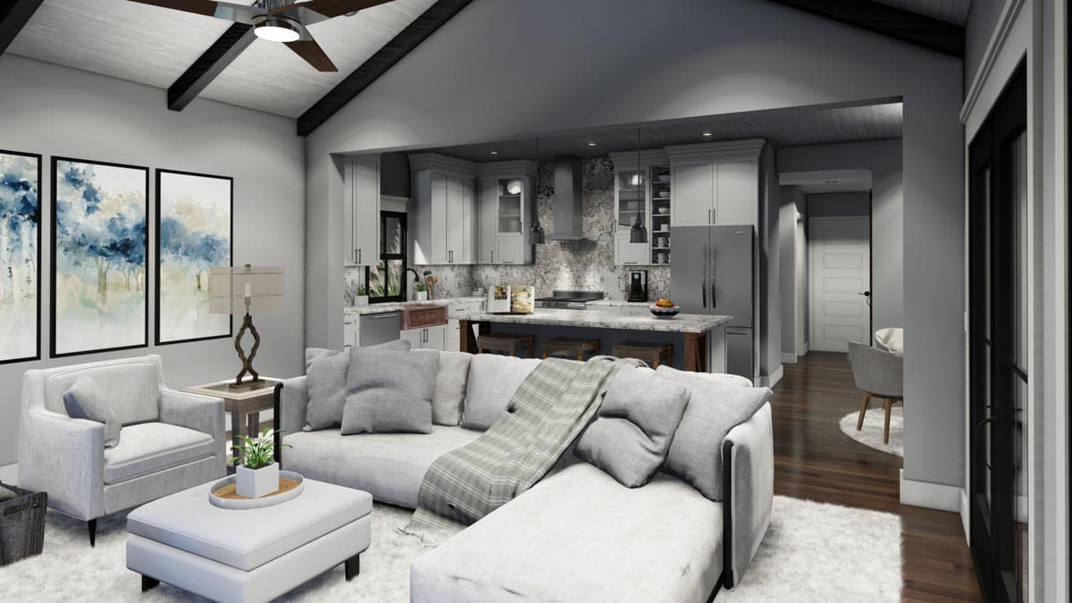 Modern, open-concept living space with a large sectional sofa, kitchen, and dining area. Artwork and a ceiling fan add to the design.