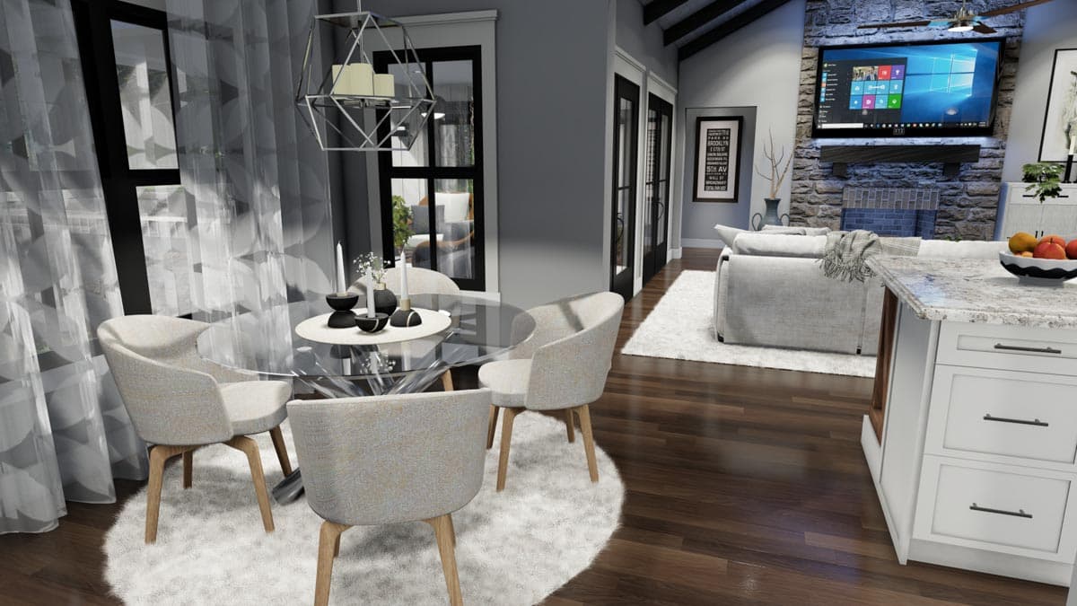 Modern dining area with a glass table and upholstered chairs, a soft rug, and large windows with sheer curtains. A nearby kitchen island is visible.