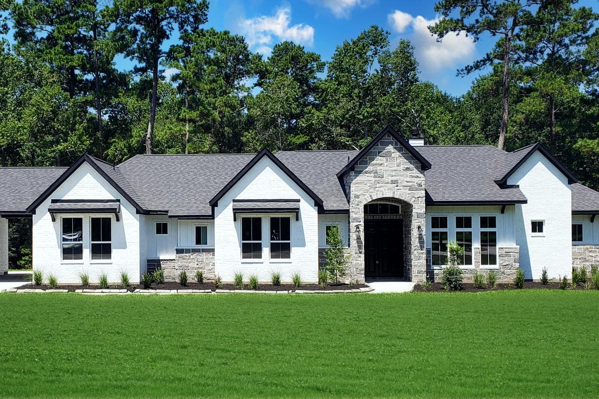House plan exterior. One-story Modern Farmhouse with gabled roof, stone accents on entry and foundation, and contrasting black trim.