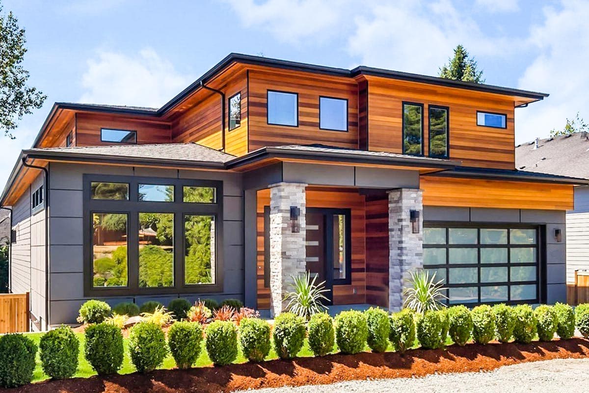 Modern house plan exterior with wood siding, stone accents, flat rooflines, large windows, and glass garage door.