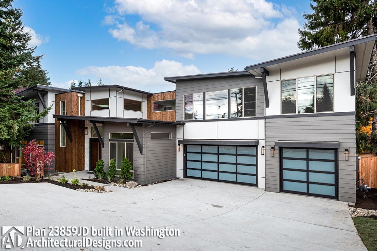 Modern house plan exterior with multiple levels, wood and gray siding, and two glass panel garage doors.
