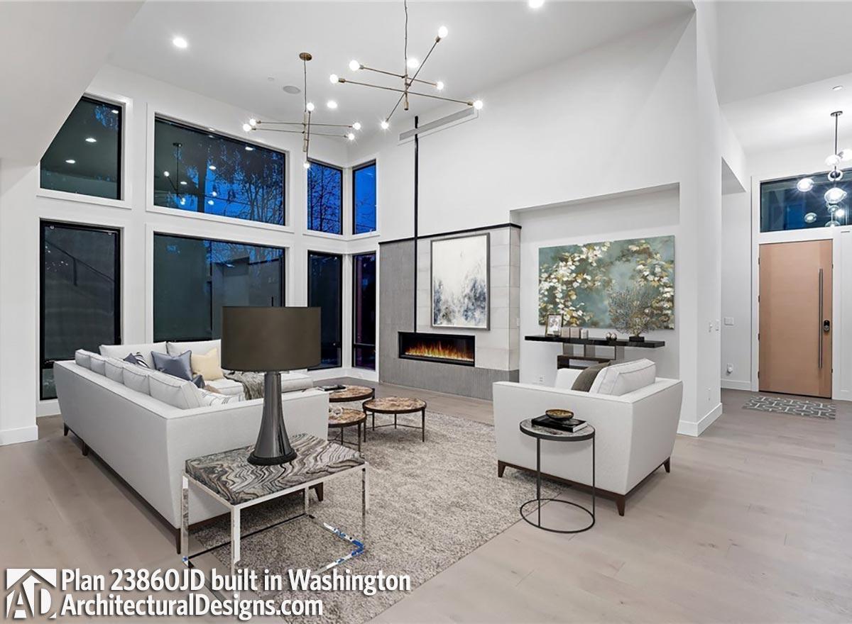 Modern living room with floor-to-ceiling windows, linear fireplace, and contemporary light fixtures.