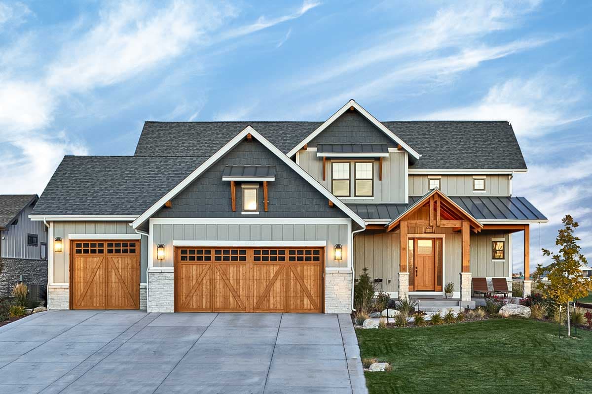 House plan exterior. Two-story Modern Farmhouse with gables, a covered porch, and a side-entry garage. Features include wood garage doors.