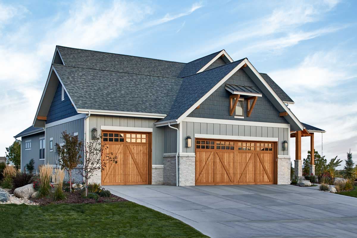 House plan exterior featuring a Modern Farmhouse style with a three-car garage, gables, and stone accents.