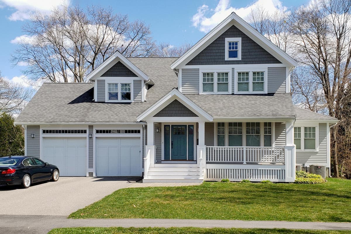 House plan exterior view of a two-story Craftsman home. Features include a front porch, multiple gables, and a two-car garage.
