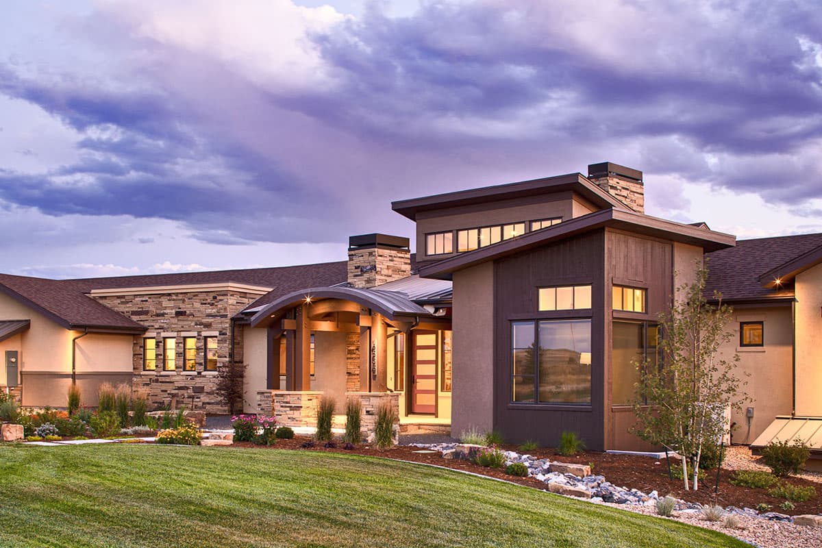 House plan exterior, contemporary style, featuring stone and wood siding, multiple rooflines, prominent chimneys, and a covered entry.