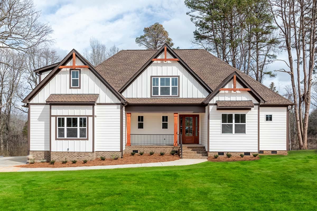 House plan exterior. Craftsman style, two-story home with gabled roofline, front porch with decorative posts, and multiple dormers.