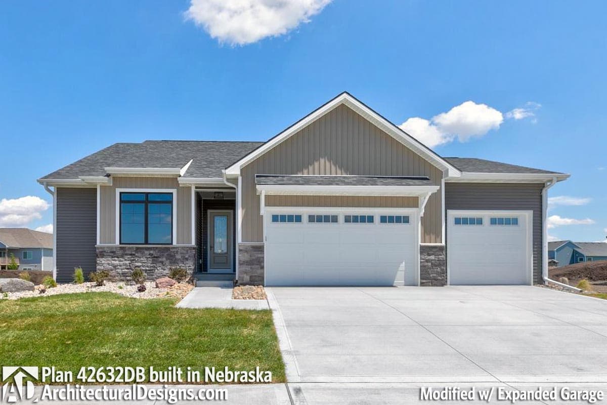 House plan exterior: Ranch style, single story with a prominent gable, stone accents, and a three-car garage.