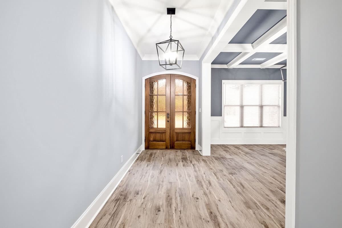 Interior view: Entryway with double wooden doors, coffered ceiling, and modern lantern pendant light.