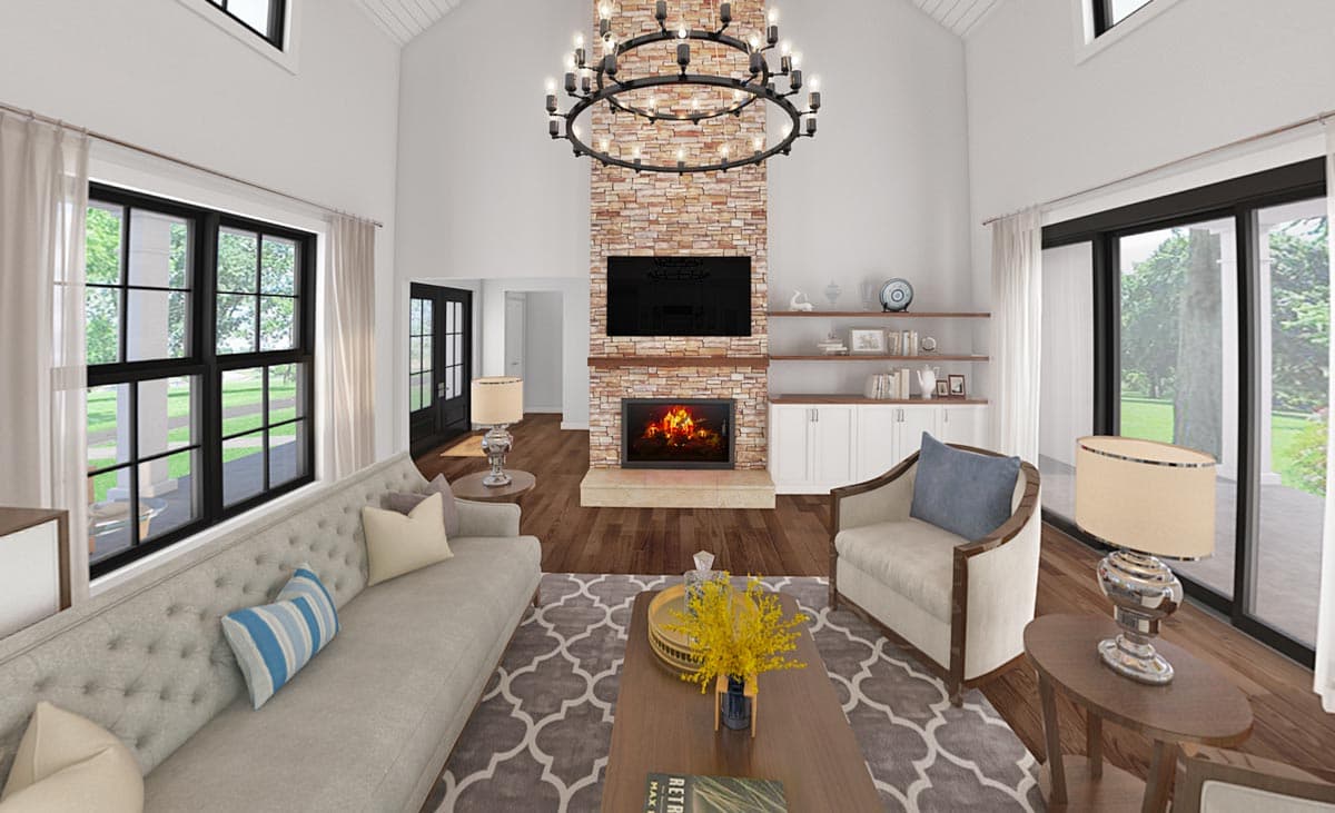 Interior view of a great room with vaulted ceiling, stone fireplace, and large windows.