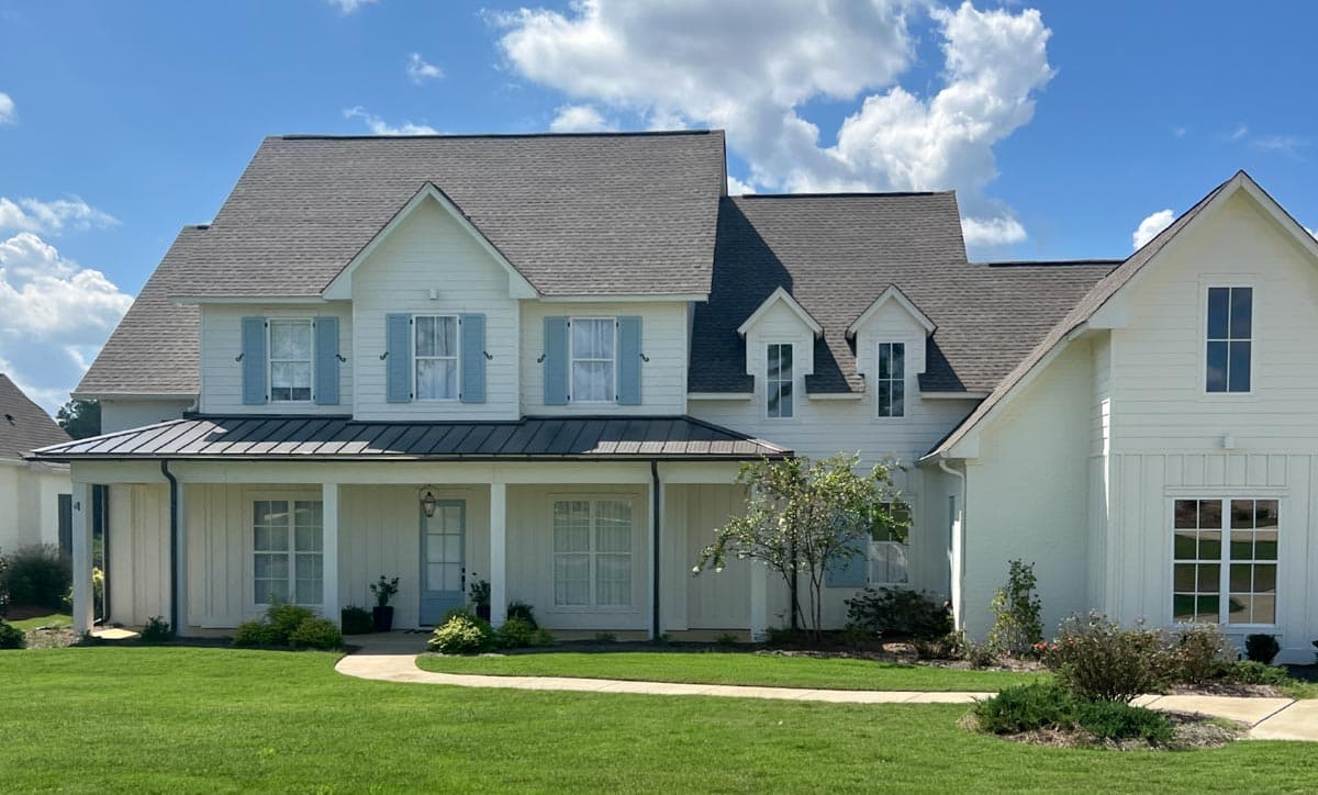 Modern Farmhouse style house plan exterior with a wraparound porch, multiple gables, and dormer windows.