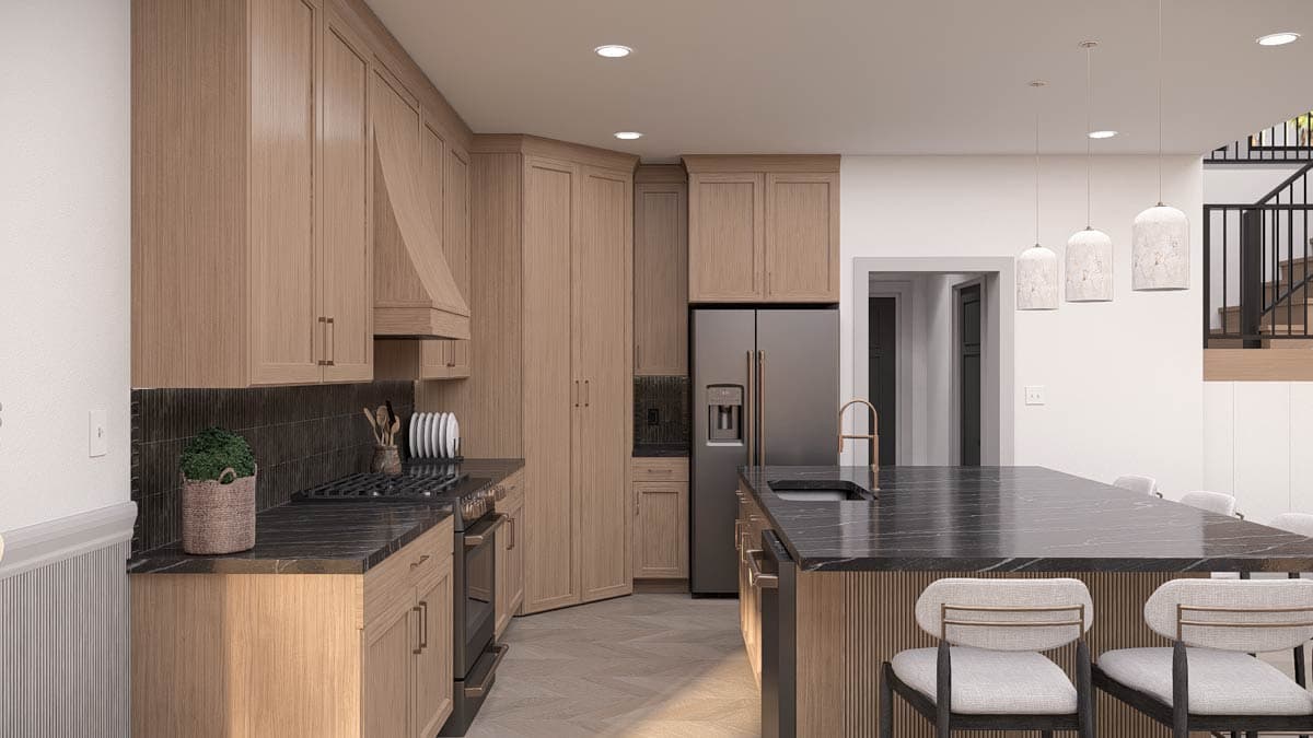 A modern kitchen with light wood cabinets, dark countertops, and a large island with bar stools. A stainless steel fridge is present.