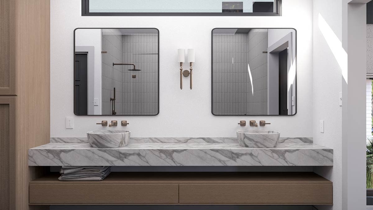 Modern bathroom with two sinks on a marble countertop, framed by two large mirrors. Features include bronze fixtures and sconces.
