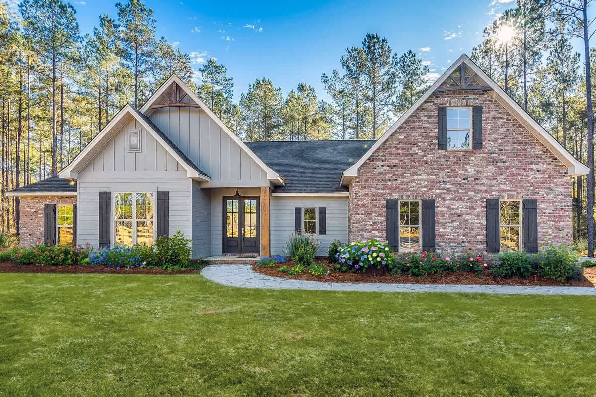 House plan exterior featuring a two-story farmhouse style with gables, brick facade, and dark shutters. The front entry has a porch and double doors.