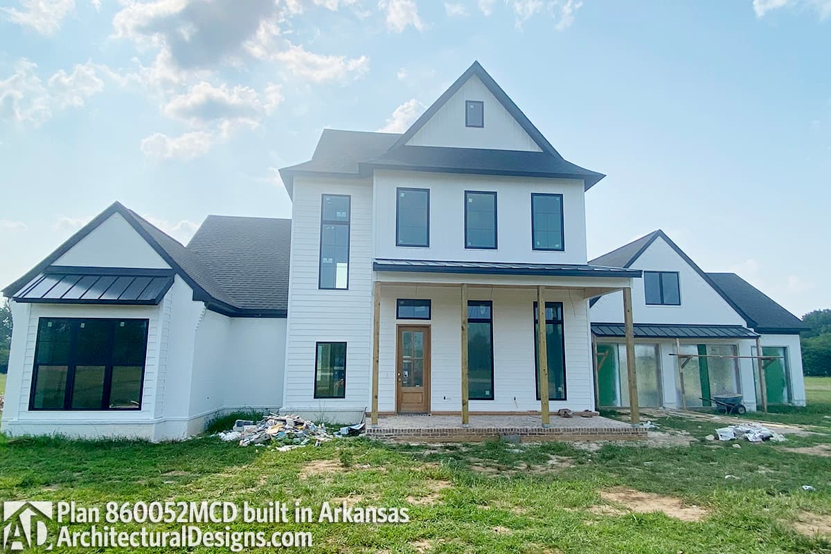Modern Farmhouse house plan exterior with white siding, black roof, gables, and covered front porch.
