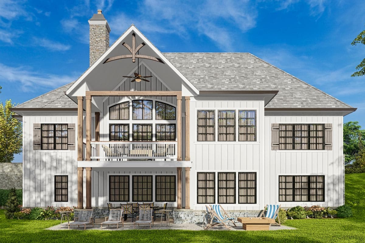Modern Farmhouse house plan exterior with white board and batten siding, stone chimney, gable dormers, and a covered balcony.