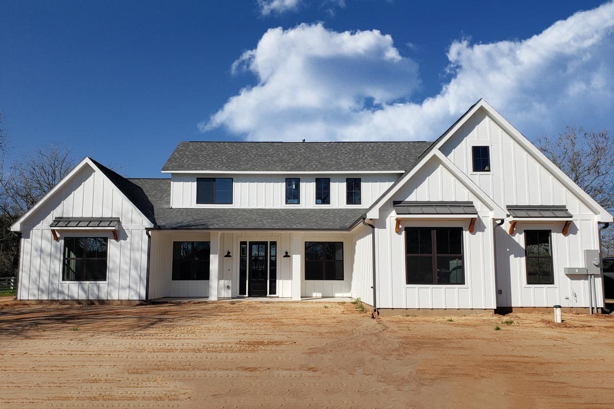 Modern Farmhouse house plan exterior with vertical siding, prominent gables, dark-framed windows, and a covered entry.