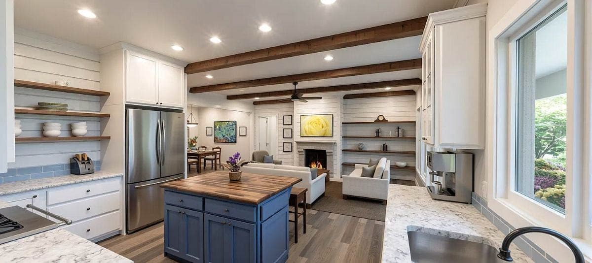 Open-concept kitchen and great room with island, fireplace, shiplap accent walls, and exposed wood beams.