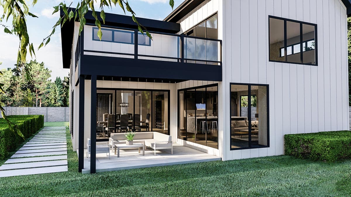 Modern house exterior with two stories, expansive windows, upper balcony, and open patio.
