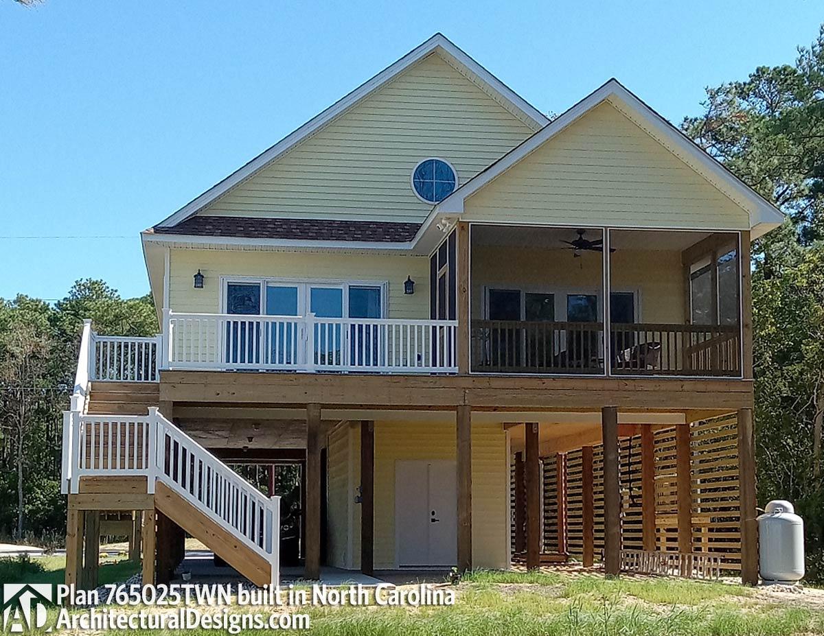 House plan exterior: Two-story stilt house with wraparound deck, screened porch, and gabled roof.