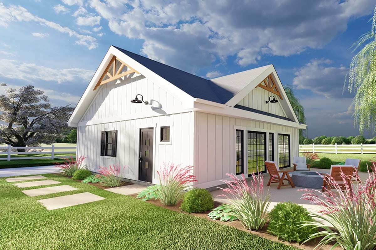 House plan exterior. One story with gabled roof, exposed rafter tails, and a patio with seating. Barn-style exterior with black framed windows.