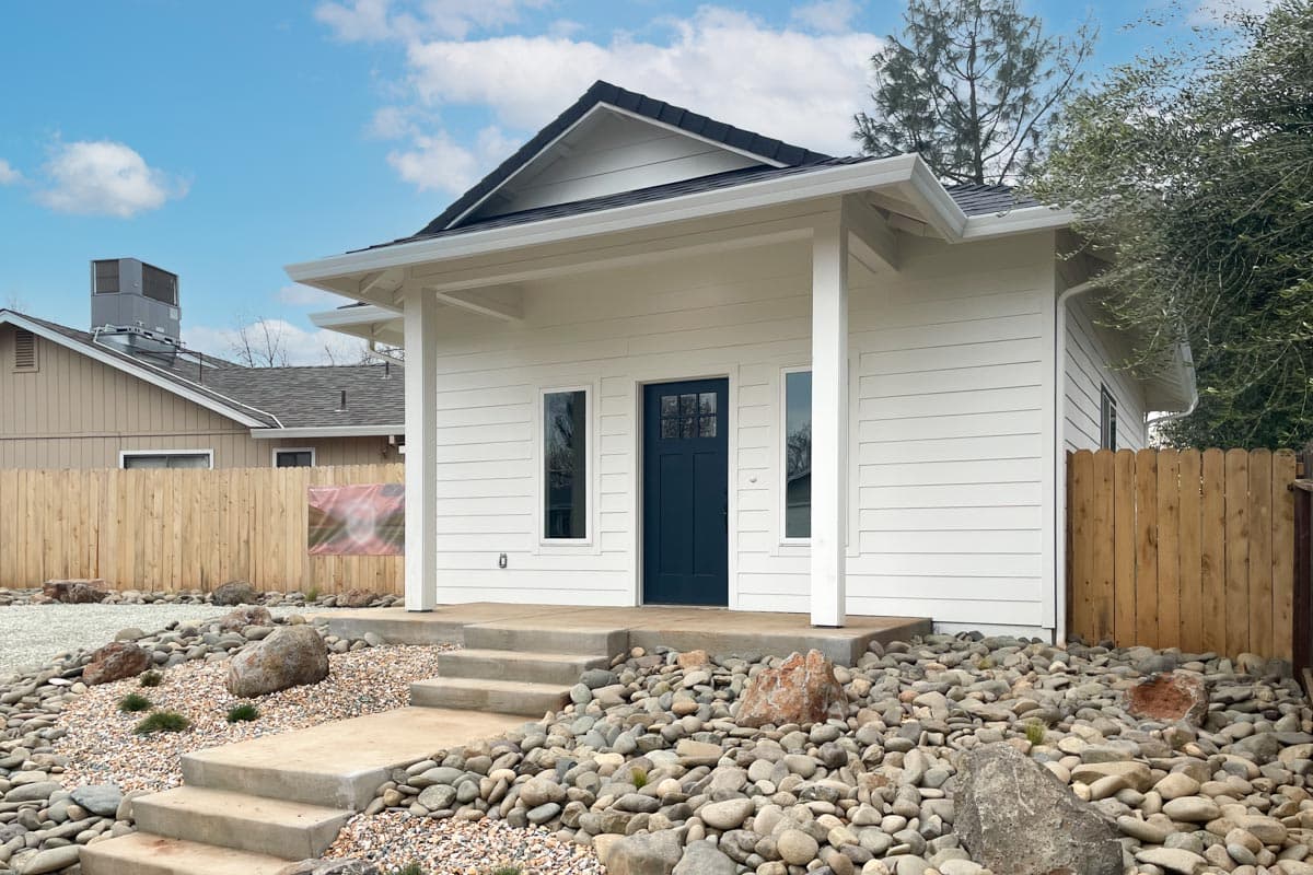 Modern house plan exterior with a gabled roof, covered porch, and horizontal siding.