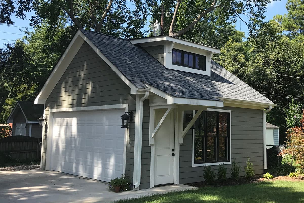 House plan exterior with Craftsman style. Features include a gable roof, dormer, and attached garage. Exterior has horizontal siding.