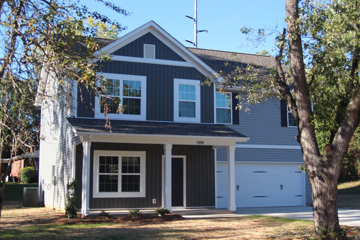 Two-story house plan exterior with gabled dormer, covered front porch, and a two-car garage.
