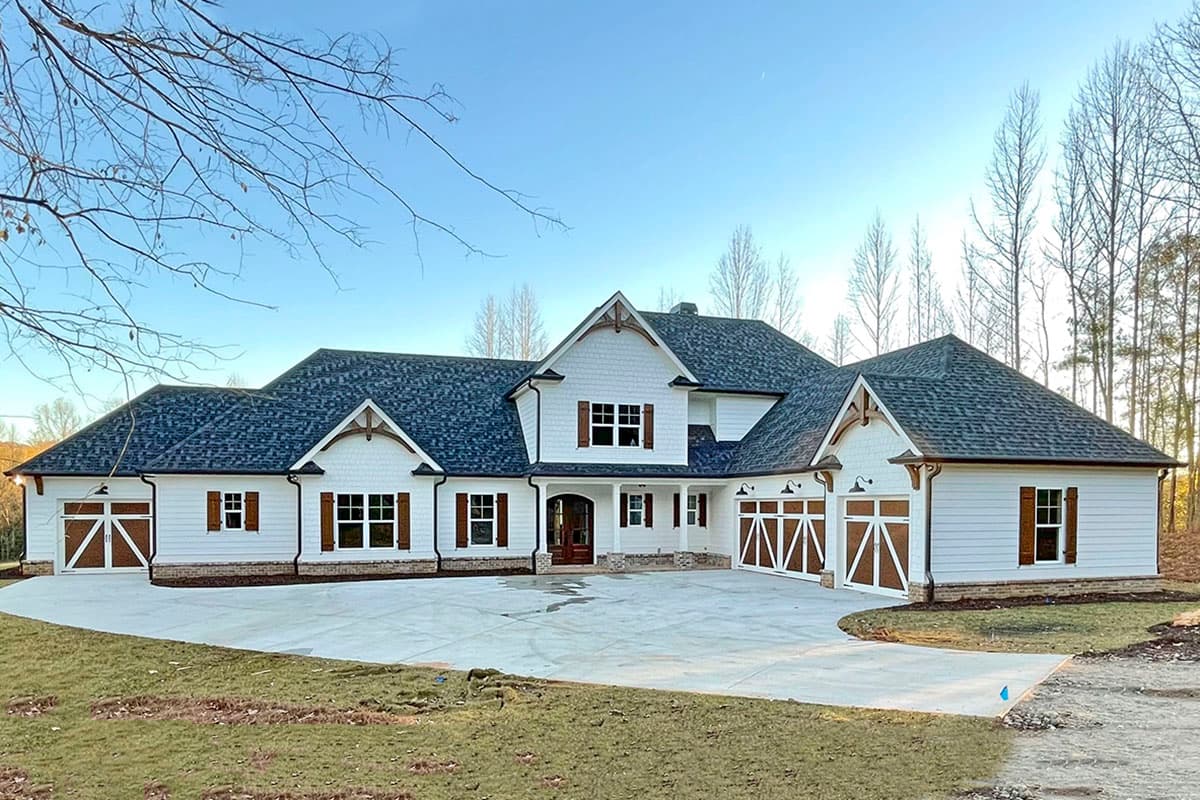House plan exterior: Two-story Modern Farmhouse with white siding, gables, and a triple-bay garage.