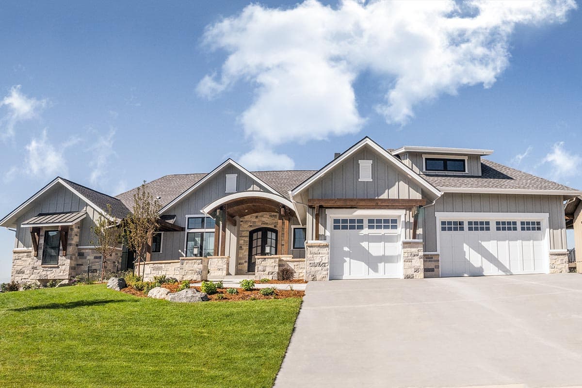 House plan exterior with Craftsman style, two stories, covered entry porch, gabled rooflines, and a two-car garage.