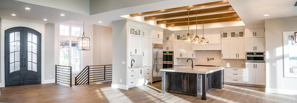 Interior rendering of open concept kitchen with island, white cabinetry, stainless steel appliances, and wood beamed ceiling.