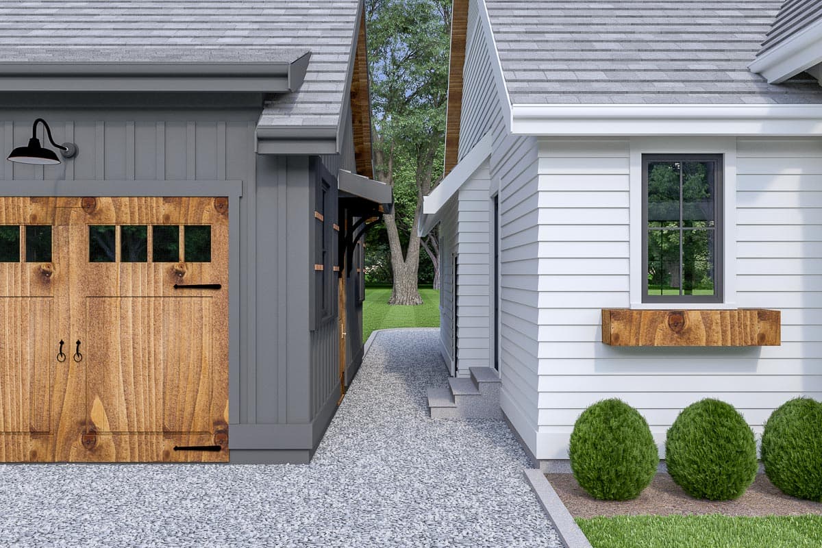 House plan exterior: Two-story design with a wooden garage door, gray siding, and white siding with a prominent window box.
