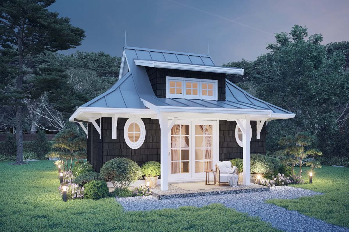 House plan exterior of a dark-shingled, one-story cottage with a standing seam metal roof, French doors, and round windows.