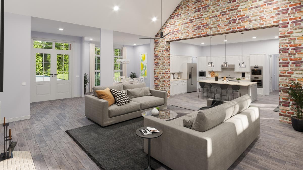 Open-concept living area and kitchen with vaulted ceiling, exposed brick accents, island with seating, and double doors.