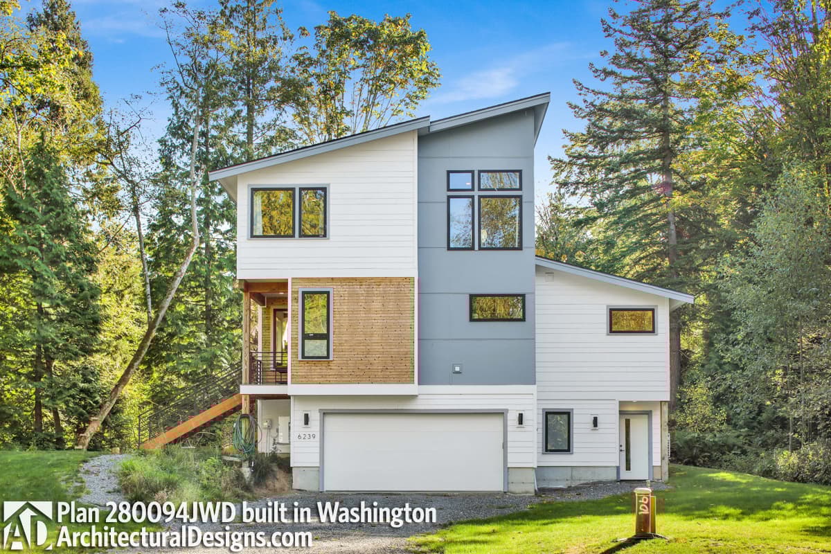 Modern house plan exterior with asymmetrical gables, wood siding accents, large windows, and a two-car garage.