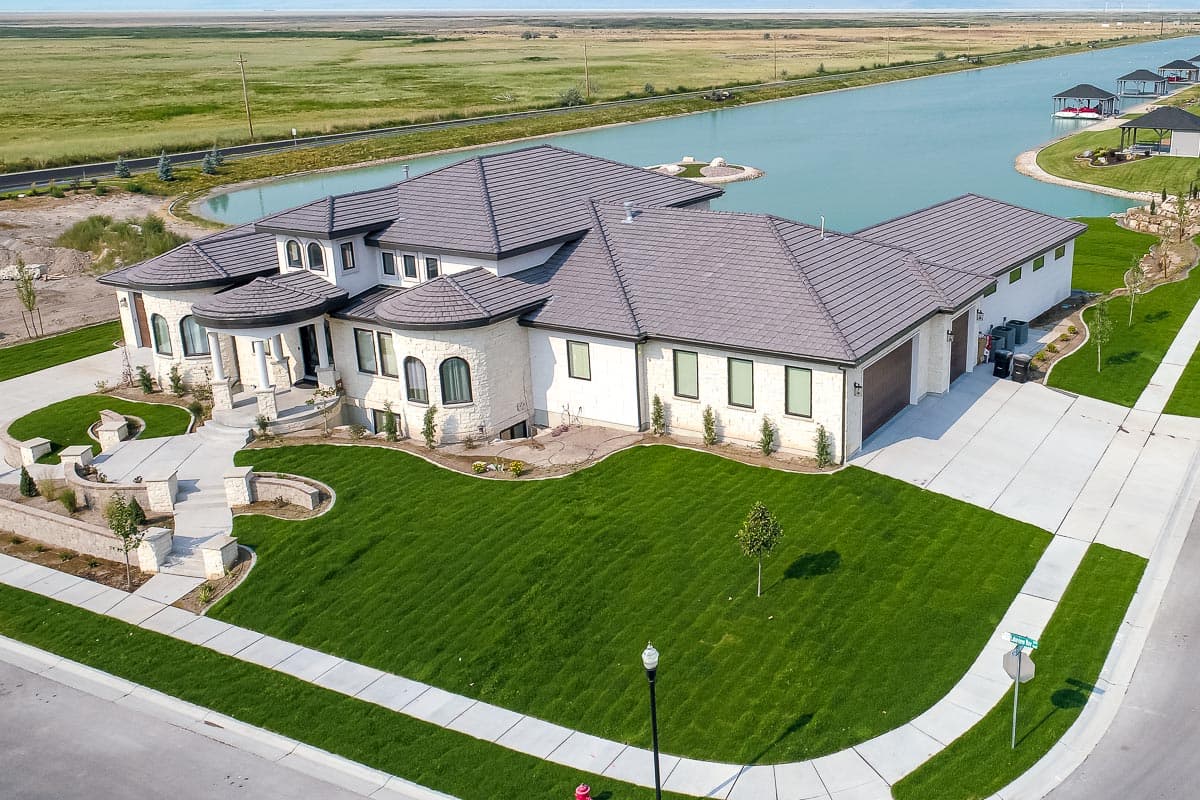 House plan exterior: Modern design with a curved entrance, multiple gables, and a three-car garage.